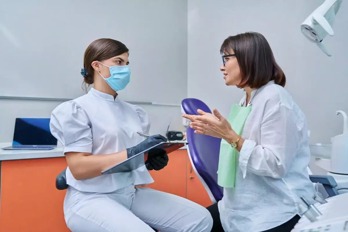Two women talking in a dentist's office.
